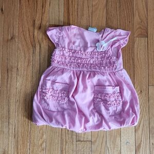Girl's ruffled baby doll style shirt with flower and pockets